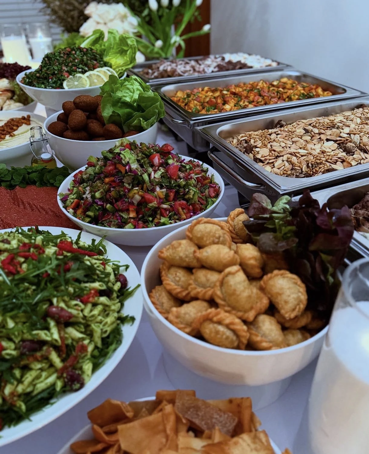 Tony’s Table Lebanese catering spread with fresh salads, sambousek, kebbe and hot dishes