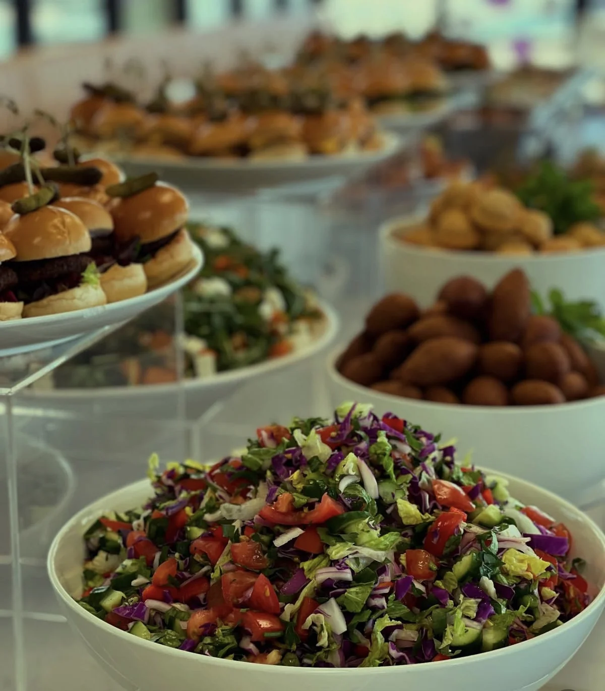 Fresh salad, sliders and kebbe on a catered table